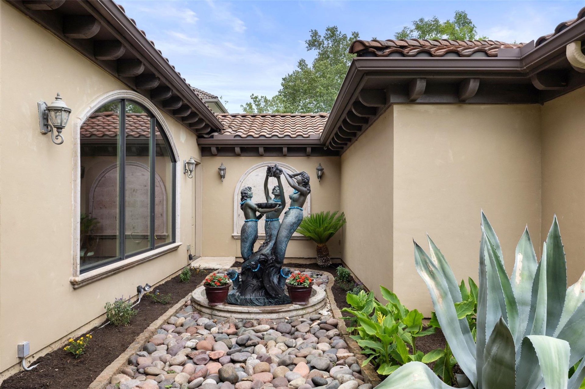 Spanish courtyard with mermaid fountain and Mediterranean landscaping